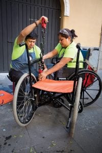 Volunteer Julio Vazquez Bernal (left), and employee Maria Isabel Nava Gomez repair a wheelchair during the Autonomy, Liberation Through Movement (ALEM) workshop in Puebla, Mexico. ALEM employs people with disabilities to design, build, and repair wheelchairs, recumbent tricycles, and custom wheeled devices, which it sells at low cost to disabled people throughout the state of Morelos. Global grant 1416582 paid for equipment, training, education, and outreach.